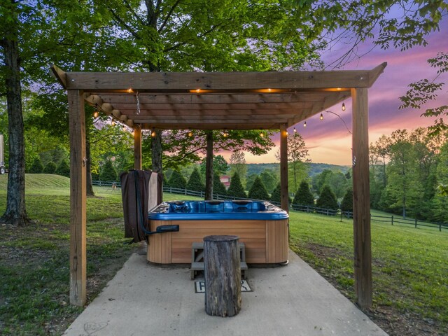 7565 N County Line Rd, Fairview, TN 37062 - patio terrace at dusk featuring a pergola, a hot tub, fence, and a yard