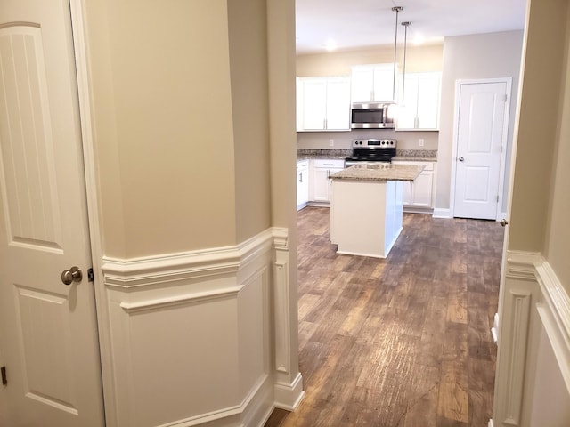 2260 Viking Ct, Murfreesboro, TN 37127 - kitchen with stainless steel appliances, dark wood-style flooring, white cabinetry, light stone counters, and a kitchen island