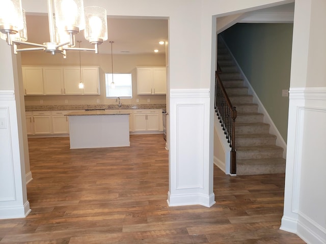 2260 Viking Ct, Murfreesboro, TN 37127 - kitchen with dark wood finished floors, an inviting chandelier, a center island, and white cabinets
