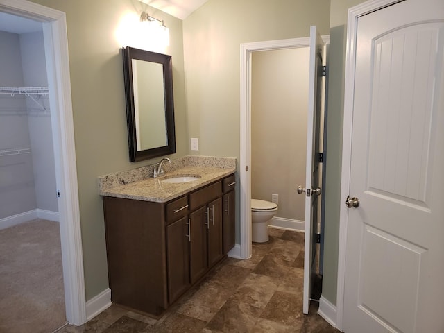 2260 Viking Ct, Murfreesboro, TN 37127 - bathroom with a walk in closet, toilet, vanity, and baseboards