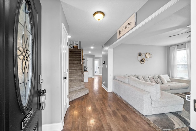 foyer entrance with a textured ceiling, dark wood-style flooring, baseboards, recessed lighting, and stairway