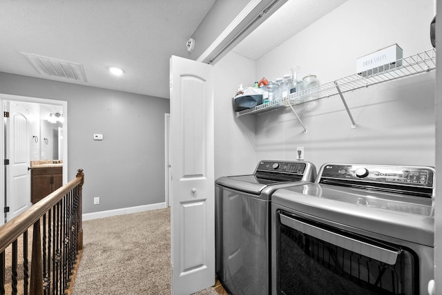 laundry room with washing machine and clothes dryer, baseboards, visible vents, light colored carpet, and laundry area