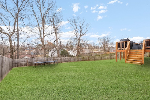 view of yard featuring a fenced backyard, a wooden deck, stairs, and a trampoline