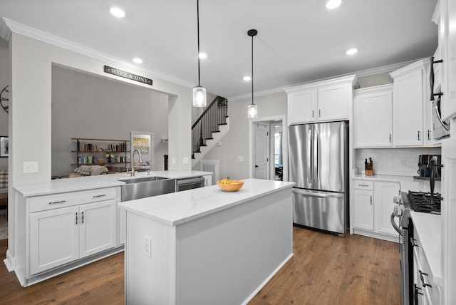 1885 Shield Dr, Clarksville, TN 37043 - kitchen with dark wood finished floors, ornamental molding, a sink, a kitchen island, and appliances with stainless steel finishes