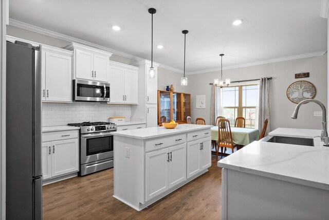 1885 Shield Dr, Clarksville, TN 37043 - kitchen featuring a sink, decorative backsplash, crown molding, a kitchen island, and appliances with stainless steel finishes