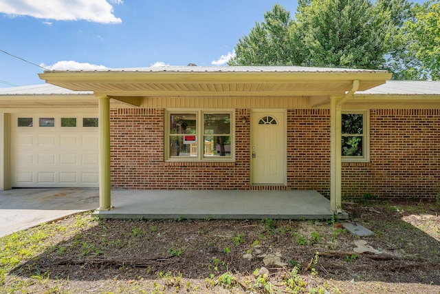 100 Hop Anderson Ln, Gainesboro, TN 38562 - view of front facade with concrete driveway, an attached garage, metal roof, and brick siding