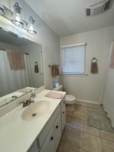 full bath featuring a textured ceiling, toilet, visible vents, tile patterned flooring, and vanity