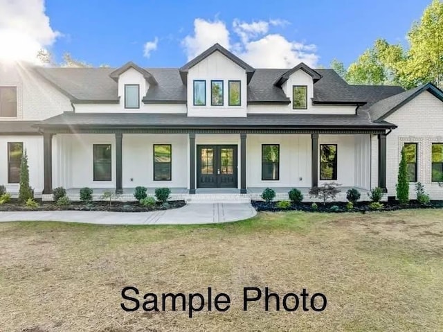 exterior space featuring roof with shingles, a porch, a yard, and french doors