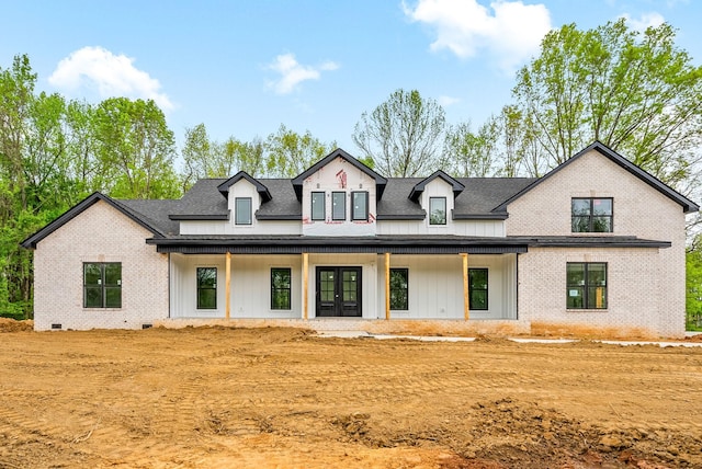 modern farmhouse style home featuring brick siding, french doors, and roof with shingles