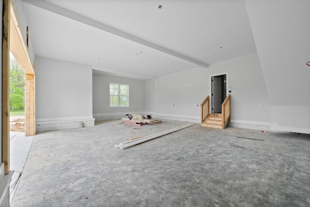 unfurnished living room with beam ceiling
