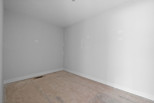 empty room featuring baseboards and visible vents