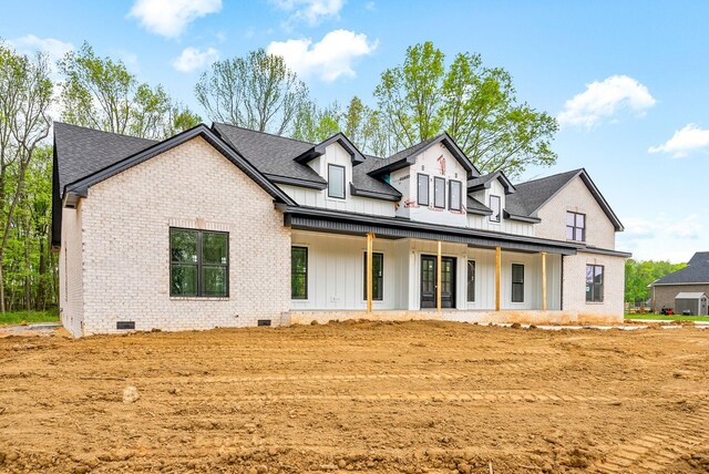 back of house featuring crawl space, central air condition unit, board and batten siding, a shingled roof, and brick siding