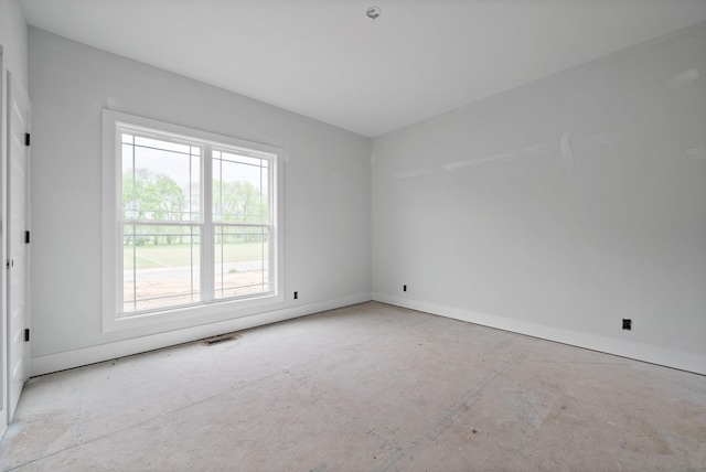 empty room featuring baseboards, visible vents, and plenty of natural light