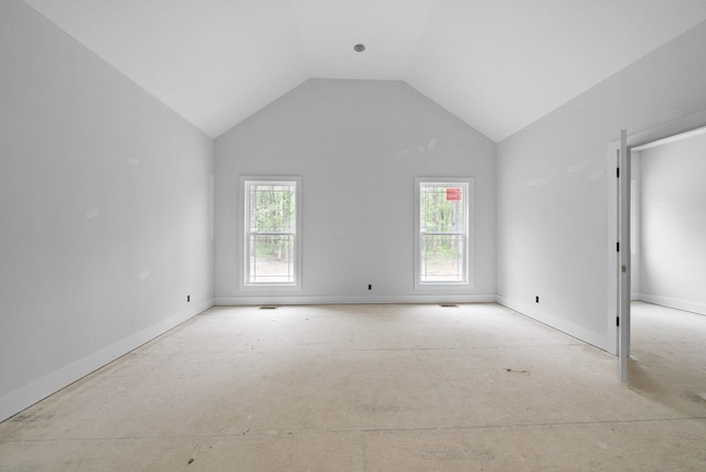 spare room featuring vaulted ceiling and baseboards