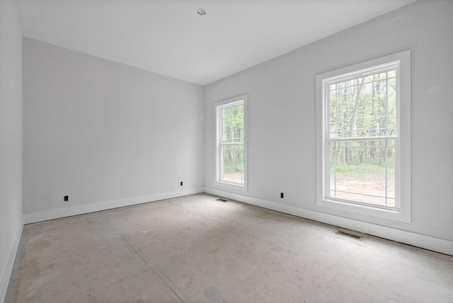 spare room with baseboards, visible vents, and concrete flooring