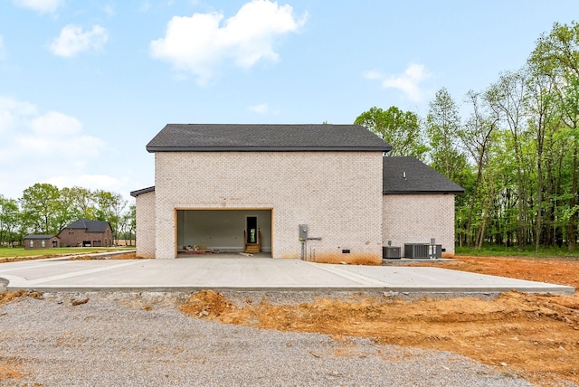 view of side of property featuring brick siding and central air condition unit