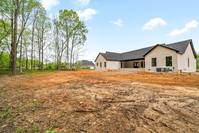rear view of property with central AC