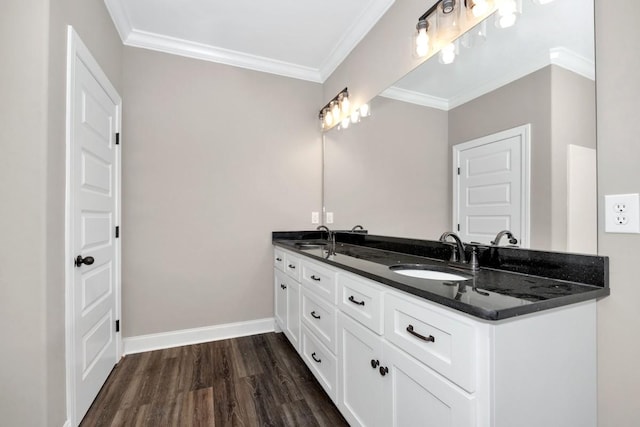 bathroom with double vanity, wood finished floors, ornamental molding, and a sink