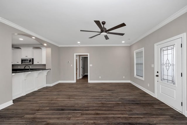 unfurnished living room featuring recessed lighting, dark wood-style floors, and ornamental molding