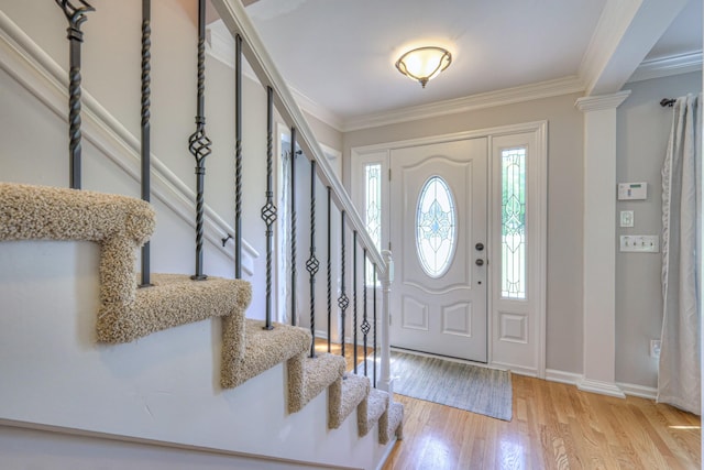entryway featuring stairway, crown molding, baseboards, and wood finished floors