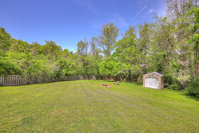 view of yard featuring an outbuilding, a shed, and a fenced backyard