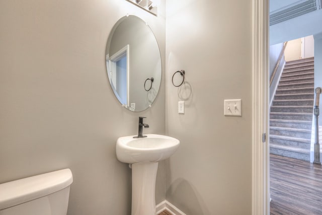 bathroom with toilet and wood finished floors