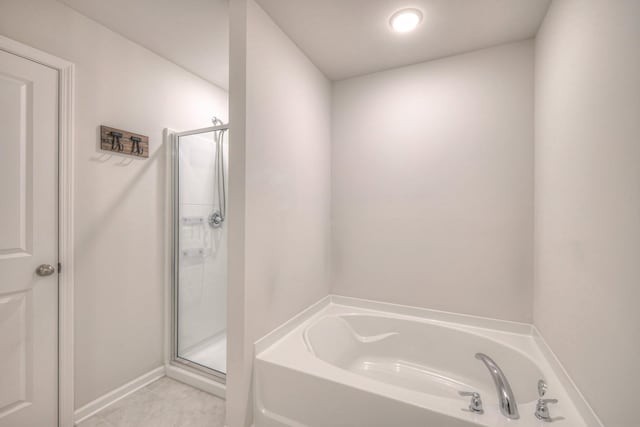 full bathroom featuring a shower stall and a garden tub