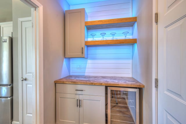 bar featuring freestanding refrigerator and wine cooler