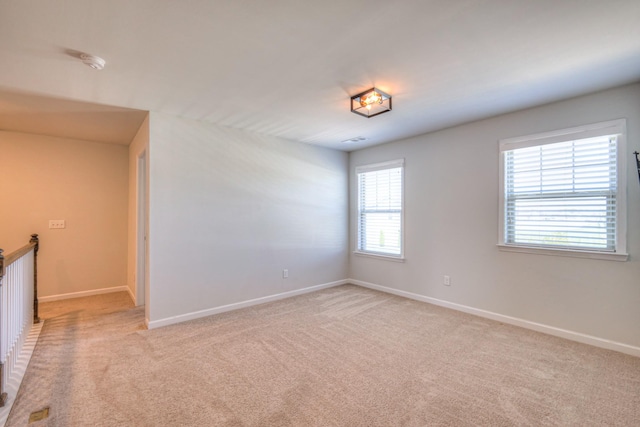 empty room with baseboards and light colored carpet