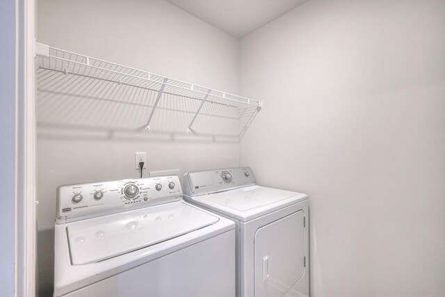 clothes washing area featuring washer and dryer and laundry area