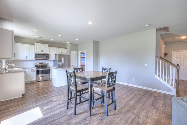 dining room with baseboards, dark wood-style flooring, stairs, and recessed lighting