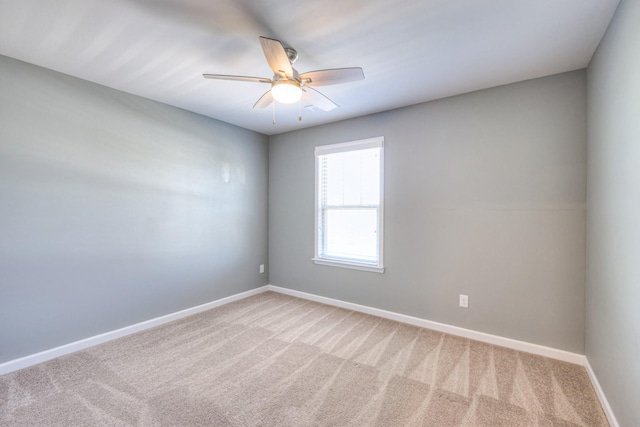 carpeted spare room with baseboards and ceiling fan