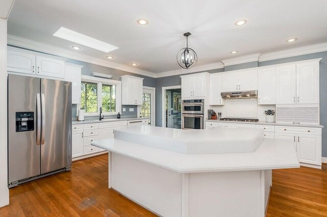1319 N Plantation Dr, Cookeville, TN 38506 - kitchen featuring a skylight, ornamental molding, appliances with stainless steel finishes, light countertops, and under cabinet range hood
