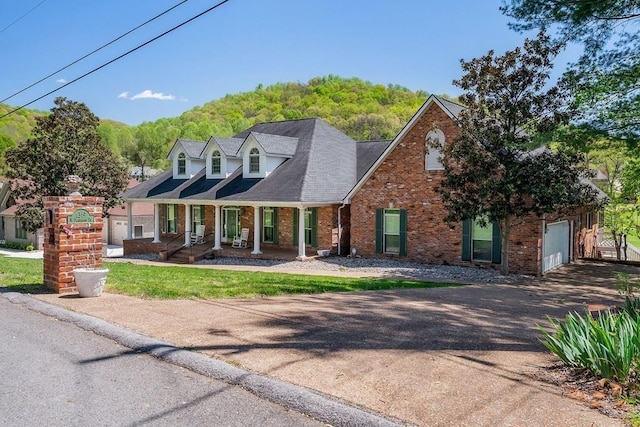 1319 N Plantation Dr, Cookeville, TN 38506 - cape cod house with aphalt driveway, a shingled roof, a porch, a garage, and brick siding