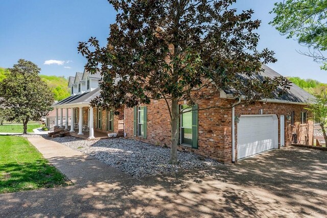 1319 N Plantation Dr, Cookeville, TN 38506 - view of front facade featuring roof with shingles, an attached garage, driveway, a porch, and brick siding