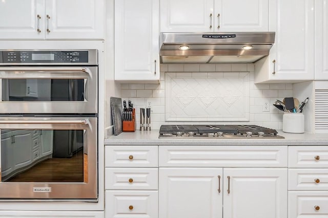 1319 N Plantation Dr, Cookeville, TN 38506 - kitchen with decorative backsplash, under cabinet range hood, stainless steel appliances, and white cabinetry