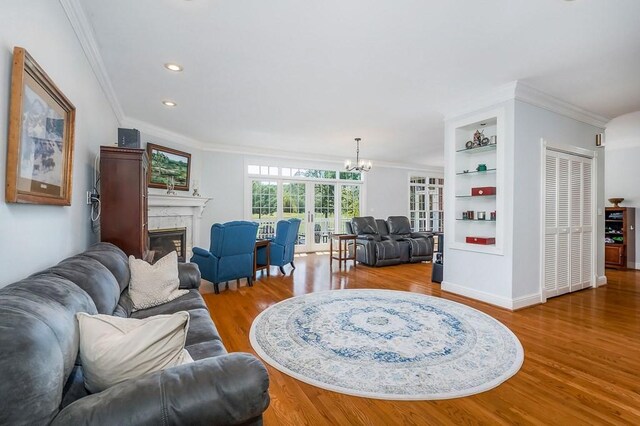 1319 N Plantation Dr, Cookeville, TN 38506 - living room featuring a glass covered fireplace, recessed lighting, a notable chandelier, wood finished floors, and crown molding