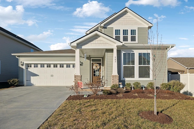 craftsman-style house featuring a garage, concrete driveway, covered porch, fence, and a front yard