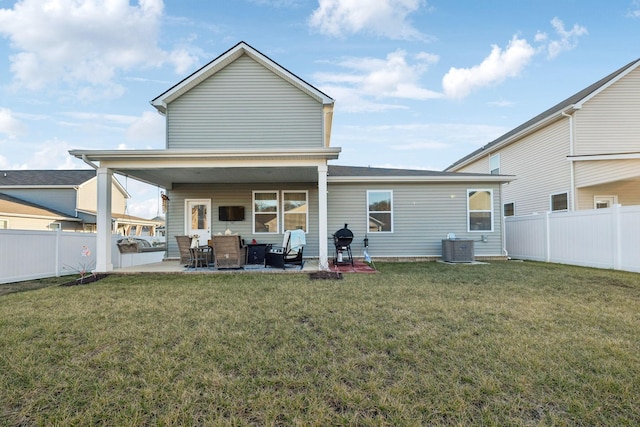 rear view of property featuring a fenced backyard, a yard, and a patio
