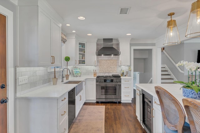 kitchen featuring a sink, wall chimney exhaust hood, gas range, black dishwasher, and white cabinetry