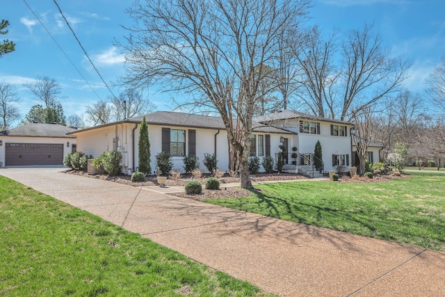 view of front of home with concrete driveway, stucco siding, a front yard, and a garage
