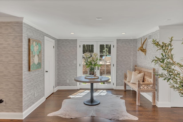 sitting room with french doors, baseboards, wallpapered walls, wood finished floors, and crown molding
