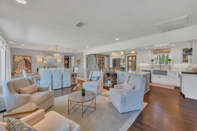 living room with dark wood finished floors, ornamental molding, visible vents, and recessed lighting