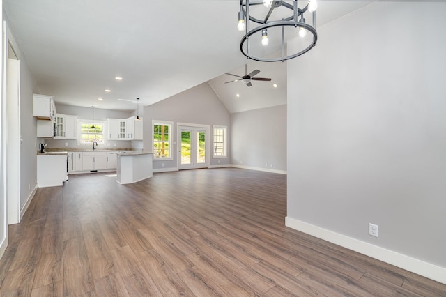 unfurnished living room featuring a sink, ceiling fan with notable chandelier, recessed lighting, baseboards, and dark wood-style floors