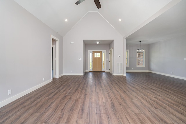 unfurnished living room with vaulted ceiling, visible vents, baseboards, and ceiling fan with notable chandelier