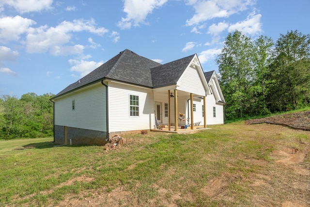 exterior space with roof with shingles, a yard, and crawl space