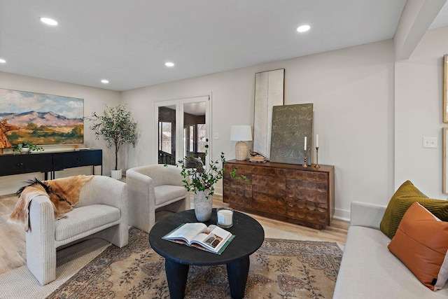 living area with baseboards, wood finished floors, and recessed lighting