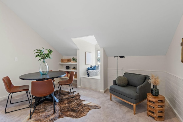dining area featuring baseboards, vaulted ceiling, and light carpet