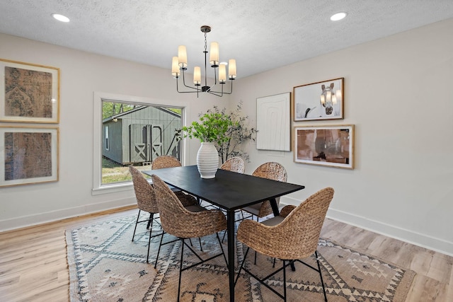dining area featuring baseboards, a textured ceiling, and a notable chandelier