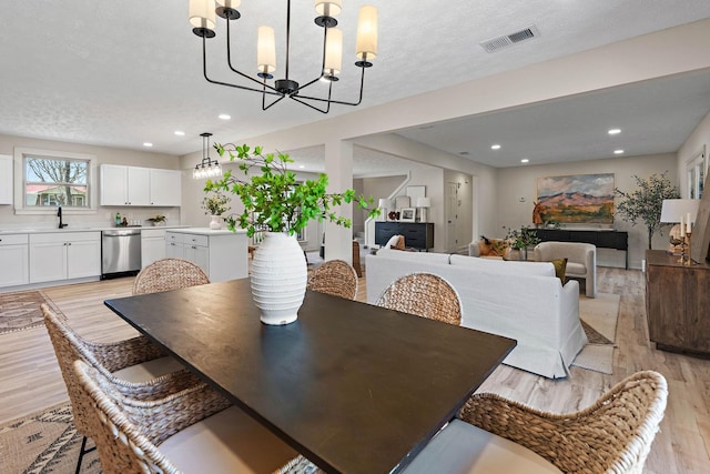 dining area with recessed lighting, visible vents, light wood-style floors, a chandelier, and a textured ceiling